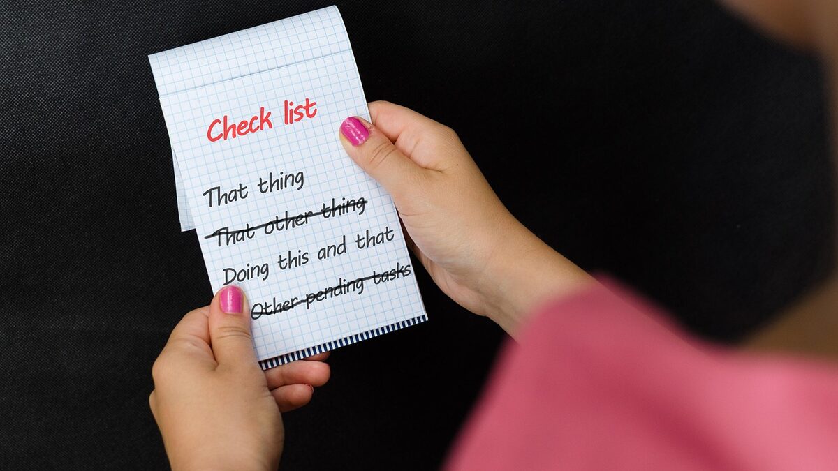 A hand holding a handwritten checklist, representing an on-page SEO checklist