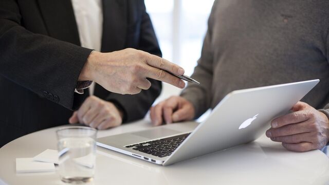 An SEO consultant reviewing strategy on a laptop with a client during a consulting meeting