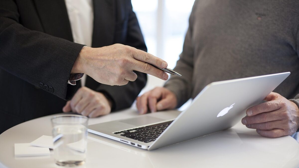 An SEO consultant reviewing strategy on a laptop with a client during a consulting meeting